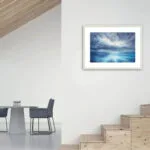 "Where Storm Meets Light" fine art print of a stormy sea watercolor painting displayed along the stairs. This blue ocean wall art adds a striking marine-inspired touch to the staircase area, bringing a dramatic and serene seascape focal point that enhances the flow of the home’s interior.