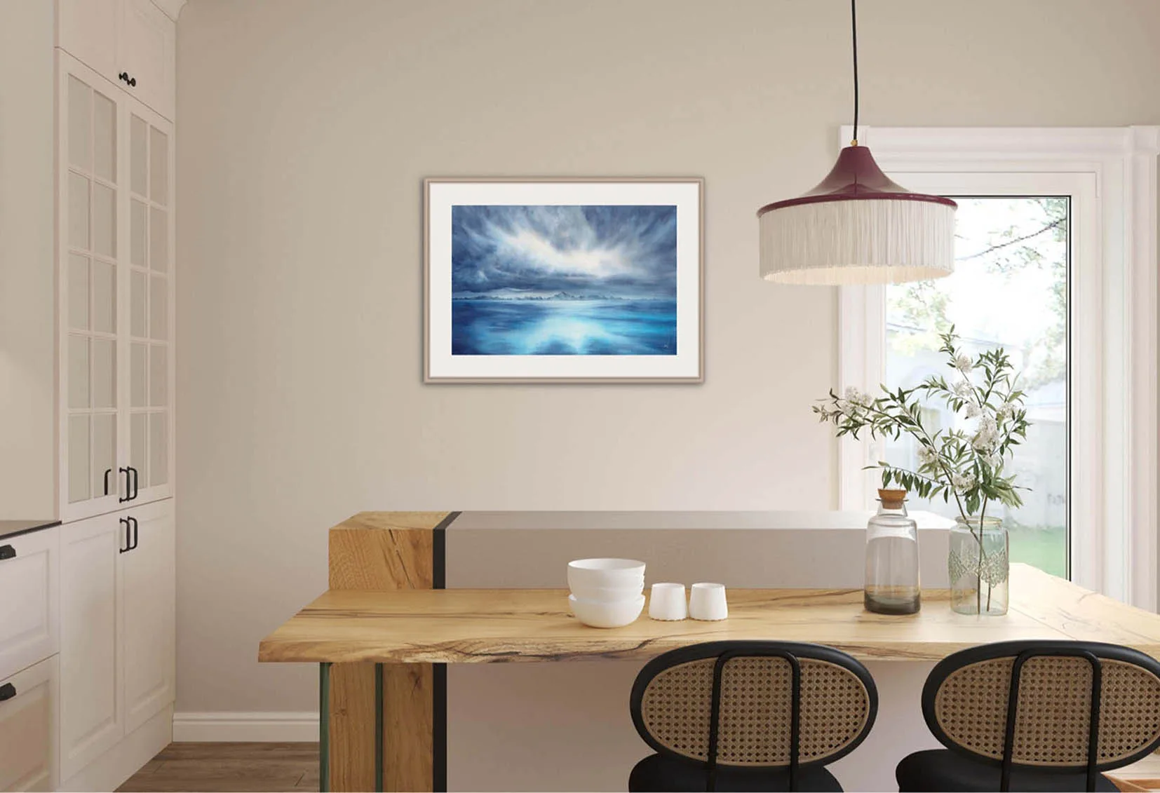 "Where Storm Meets Light" fine art print of a stormy sea watercolor painting displayed in a coastal kitchen. This blue ocean wall art brings a touch of tranquility and natural beauty to the space, complementing the marine-inspired decor and light-filled kitchen atmosphere.