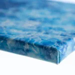 Side view of "Liquid Energy" abstract ocean watercolor painting on canvas, highlighting wrapped edges and textured surface in flowing blue tones.