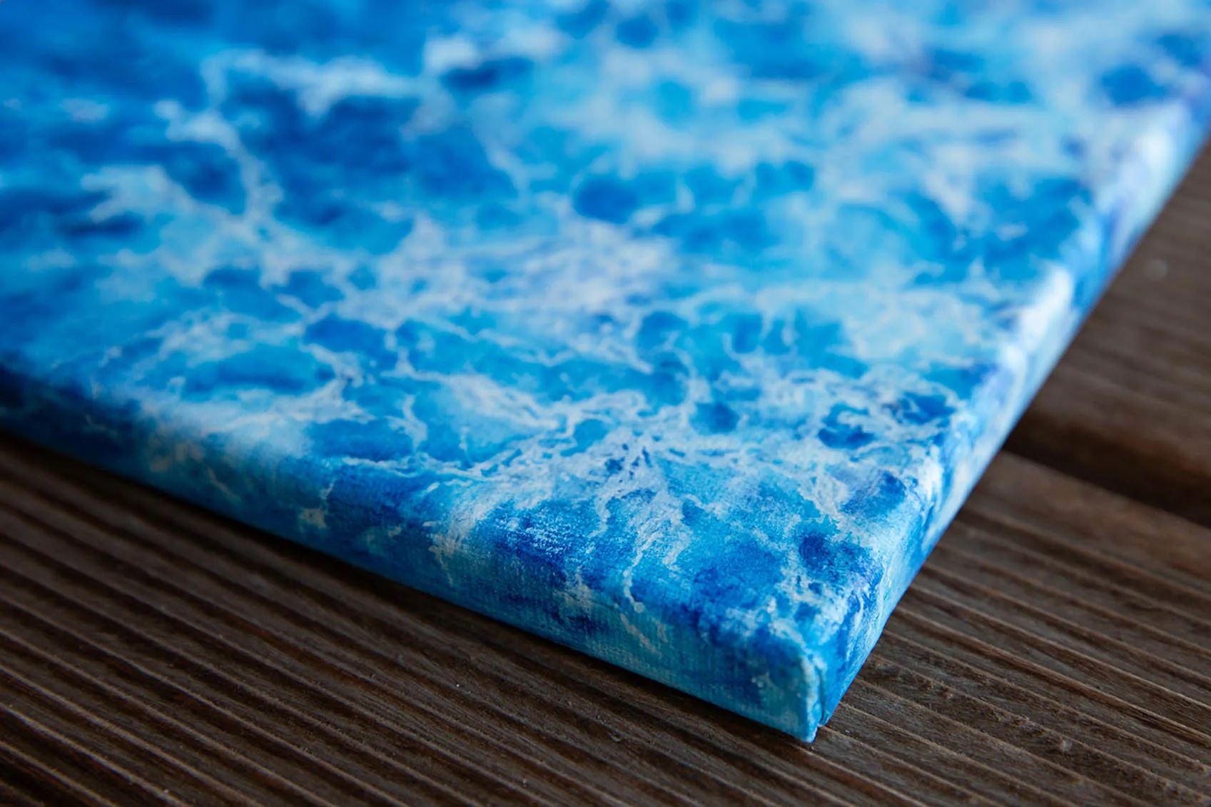 Angled side view of framed "Liquid Energy" blue ocean watercolor artwork, showing modern presentation of canvas and depth of seascape-inspired brushwork.