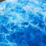 Blue abstract ocean watercolor painting "Liquid Energy" by Kateryna Nazarenko, original artwork on canvas with flowing sea waves and coastal energy.
