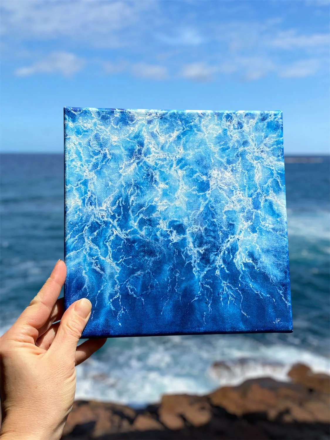 Original abstract ocean watercolor painting titled "Liquid Energy" in dynamic shades of blue, capturing fluid motion of sea water on canvas with light and depth.