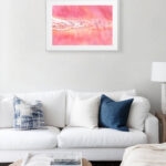 "Pink Lakes of Ukraine" painting above the sofa in a coastal living room, infusing the space with soothing pink and coral tones inspired by Ukraine’s salt lakes — nature-inspired wall art.