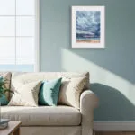 After Dark seascape watercolor artwork with dramatic storm clouds and fading light styled in a coastal living room above the sofa, perfect for beach house decor