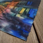 Closeup view of Kyiv. Podil. Blackout watercolor painting highlighting fine architectural details, glowing reflections on wet cobblestones, and expressive night city atmosphere