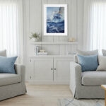 Bravery sailing boat watercolor painting framed in a coastal living room, showcasing dramatic storm waves, ocean spray, and nautical wall art that adds dynamic marine energy to the décor.