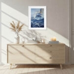 Bravery stormy ocean sailing artwork in a bright coastal living room, bringing nautical elegance, dynamic sea movement, and bold marine color tones to the interior design.