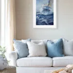 Bravery ocean storm painting hanging above a light sofa in a modern living room, adding powerful wave textures, sailing adventure, and coastal wall art style.