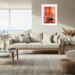 Red Sails original sailboat watercolor painting displayed in a modern living room with ocean-inspired decor and warm sunset tones.