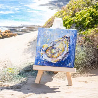 Contemporary coastal mini painting with oyster motif and wooden display easel.