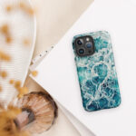 Blue green ocean watercolor iPhone case with MagSafe on table